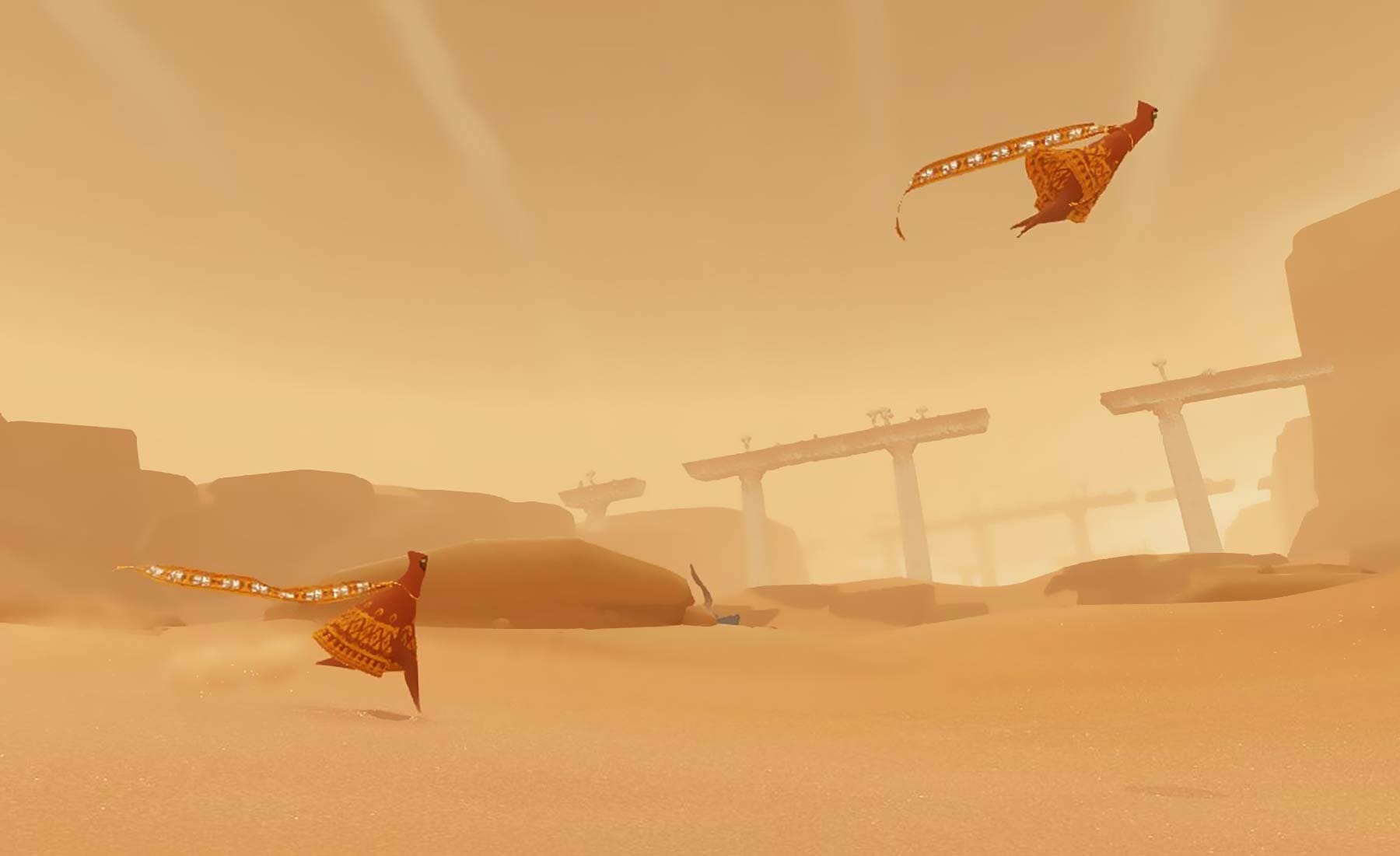 A screenshot from Journey shows one player running and another jumping as the two move through the desert.